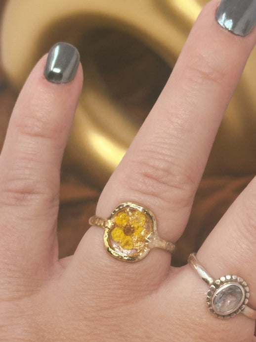 Gold plated ring coated in resin with real pressed yellow flower cast inside with resin.